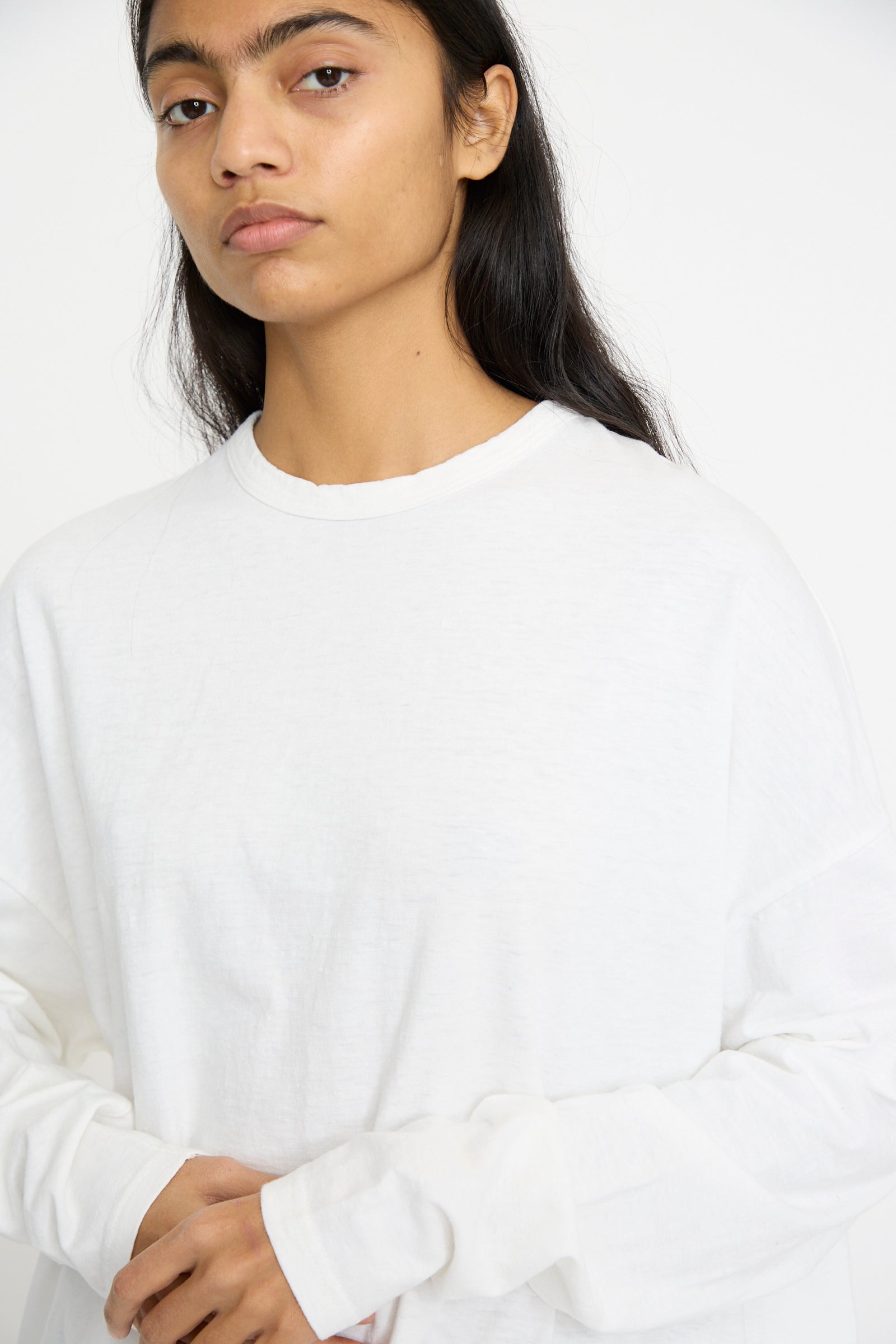 A person wearing the Cotton Loose Pullover in White by Ichi Antiquités, a relaxed fit long-sleeve shirt against a white background.