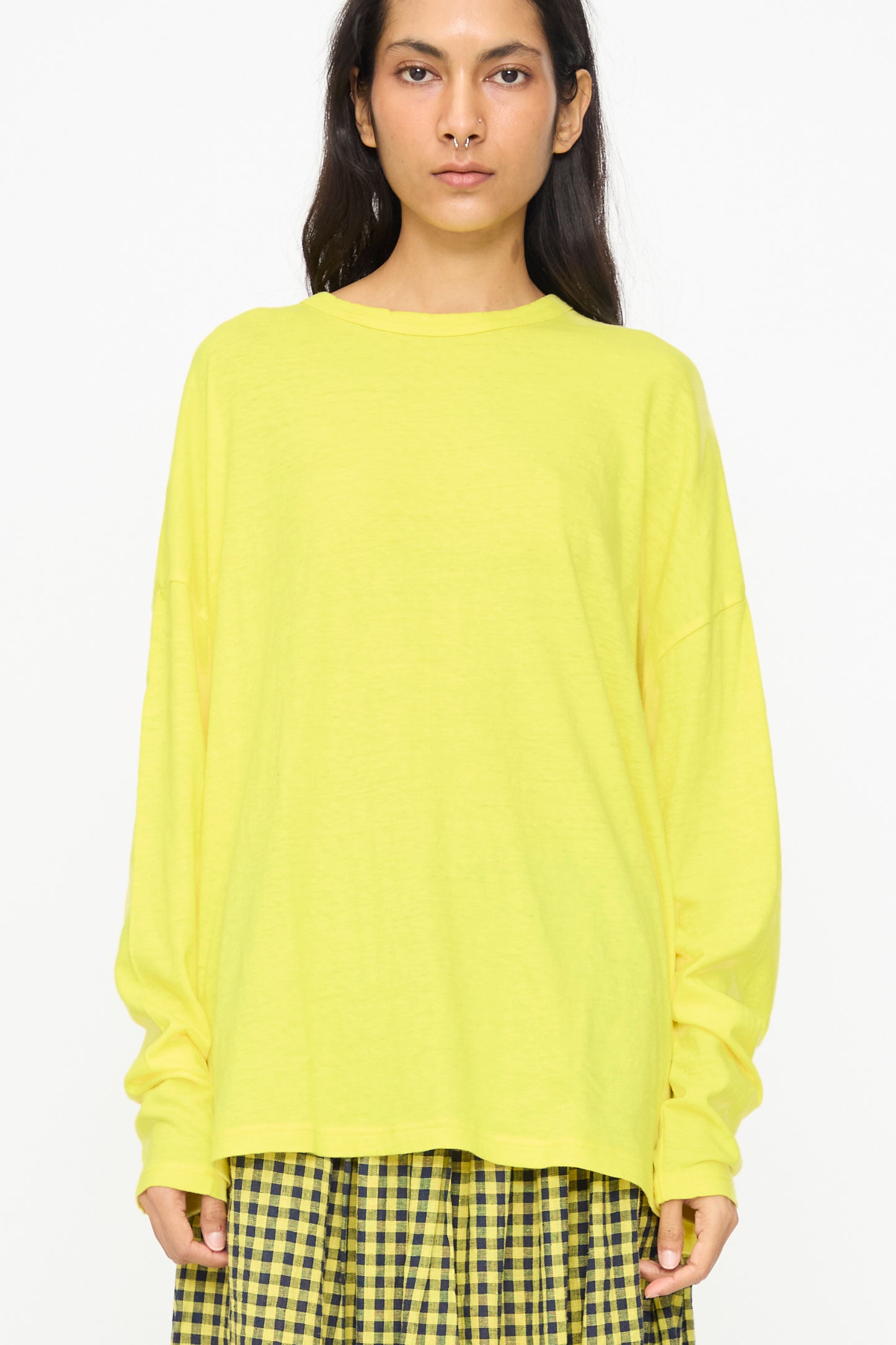 A person wears the Ichi Antiquités Cotton Loose Pullover in Yellow with a yellow plaid skirt, standing against a plain white background.