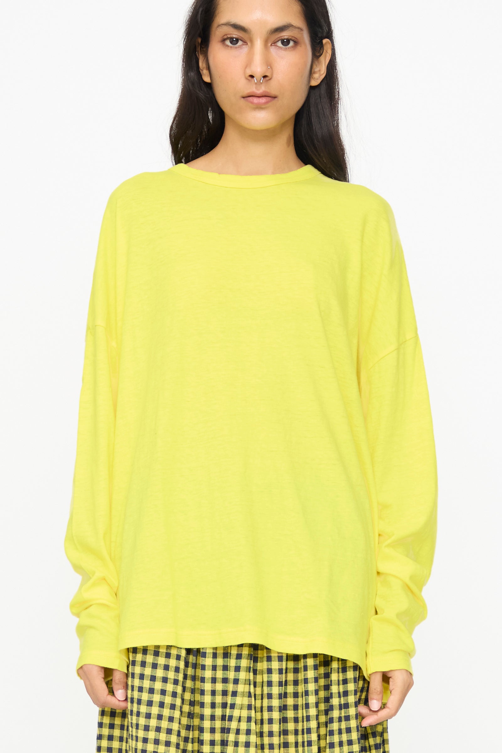 A person wears the Ichi Antiquités Cotton Loose Pullover in Yellow with a yellow plaid skirt, standing against a plain white background.
