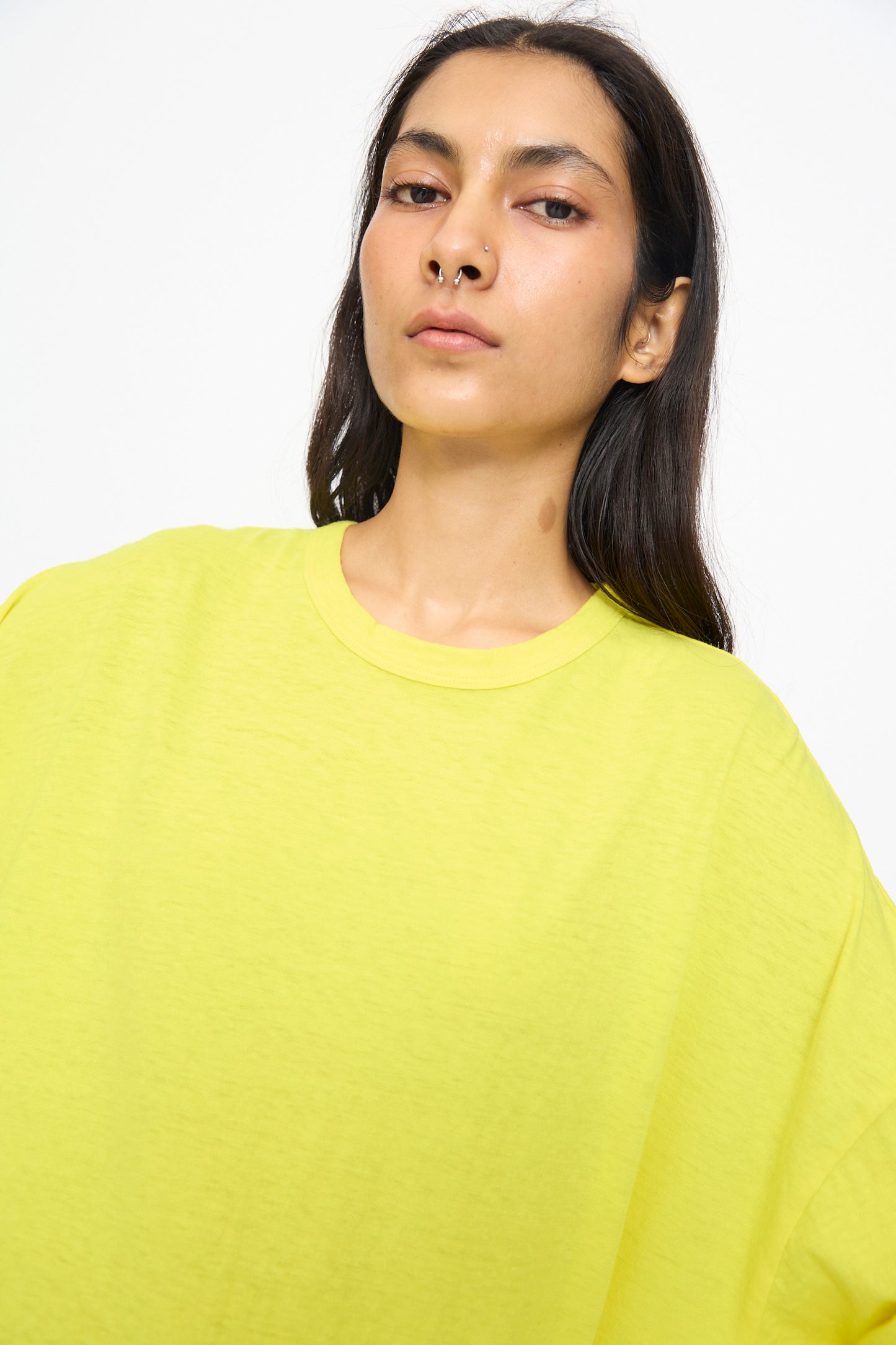 A person with long dark hair wears the Ichi Antiquités Cotton Loose Pullover in Yellow, made in Japan, standing against a plain light background and looking directly at the camera.