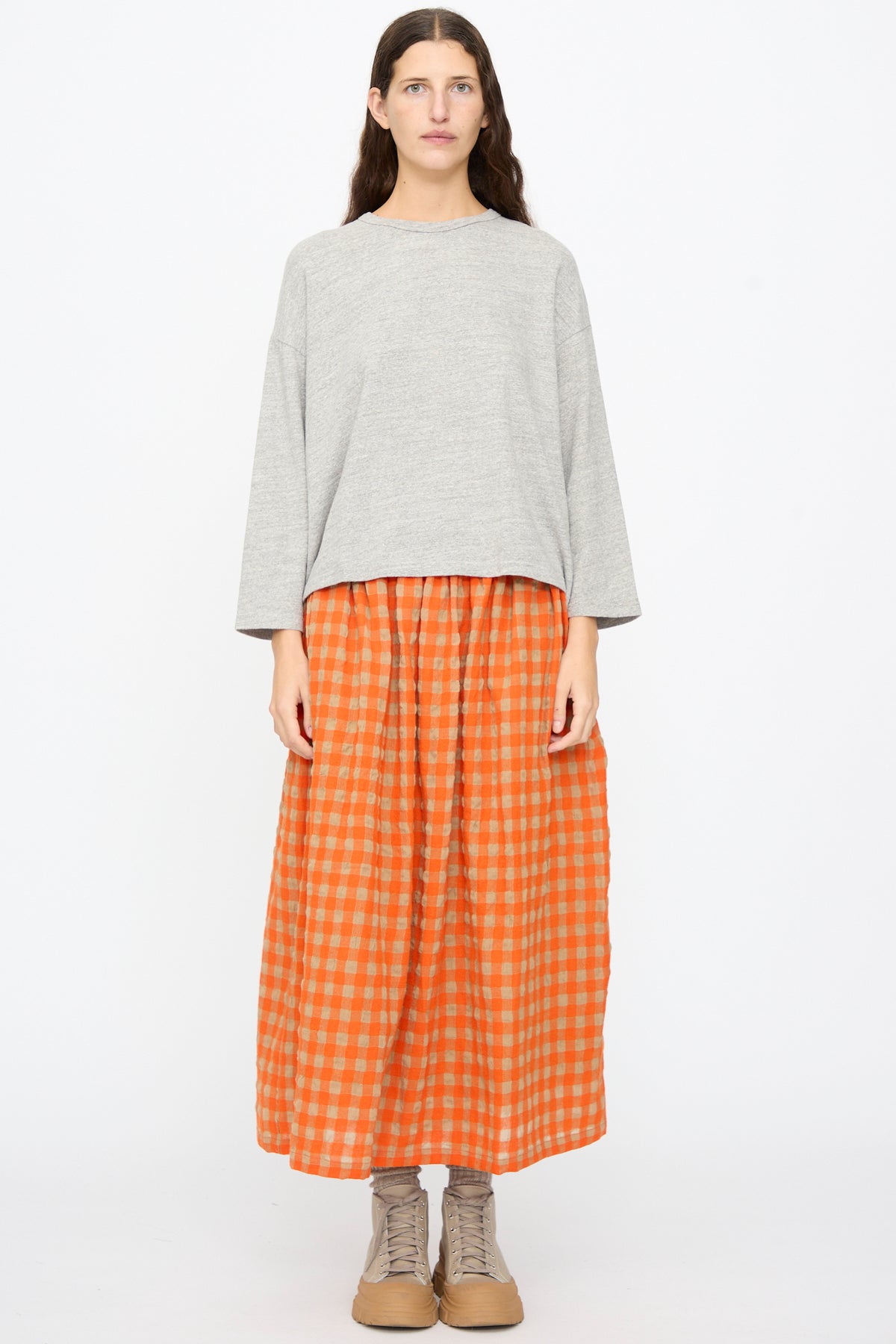 Person wearing a gray Ichi Antiquités Cotton Pullover, an orange checkered maxi skirt, and gray lace-up shoes.
