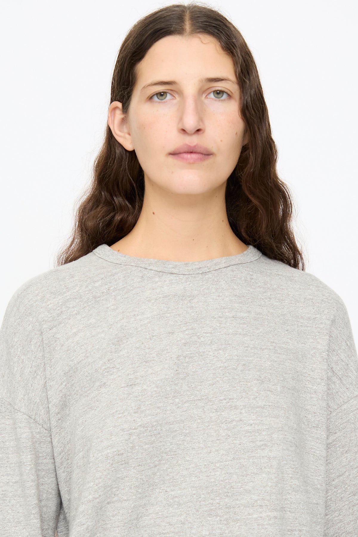 A person wearing a relaxed, gray Ichi Antiquités Cotton Pullover in Gray with a crew neck.