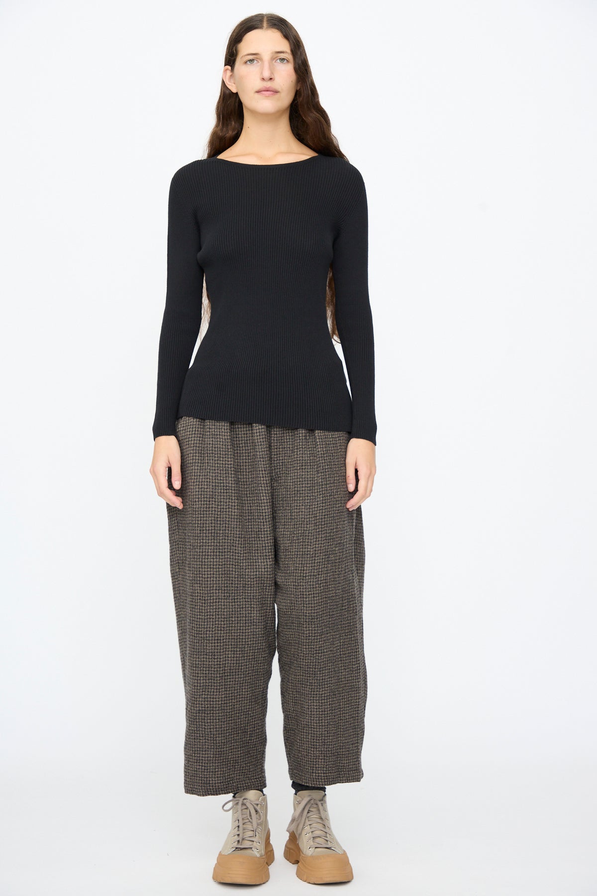 A person wearing an Ichi Antiquités Cotton Rib Knit Pullover in Black, dark patterned wide-leg trousers, and tan platform sneakers.