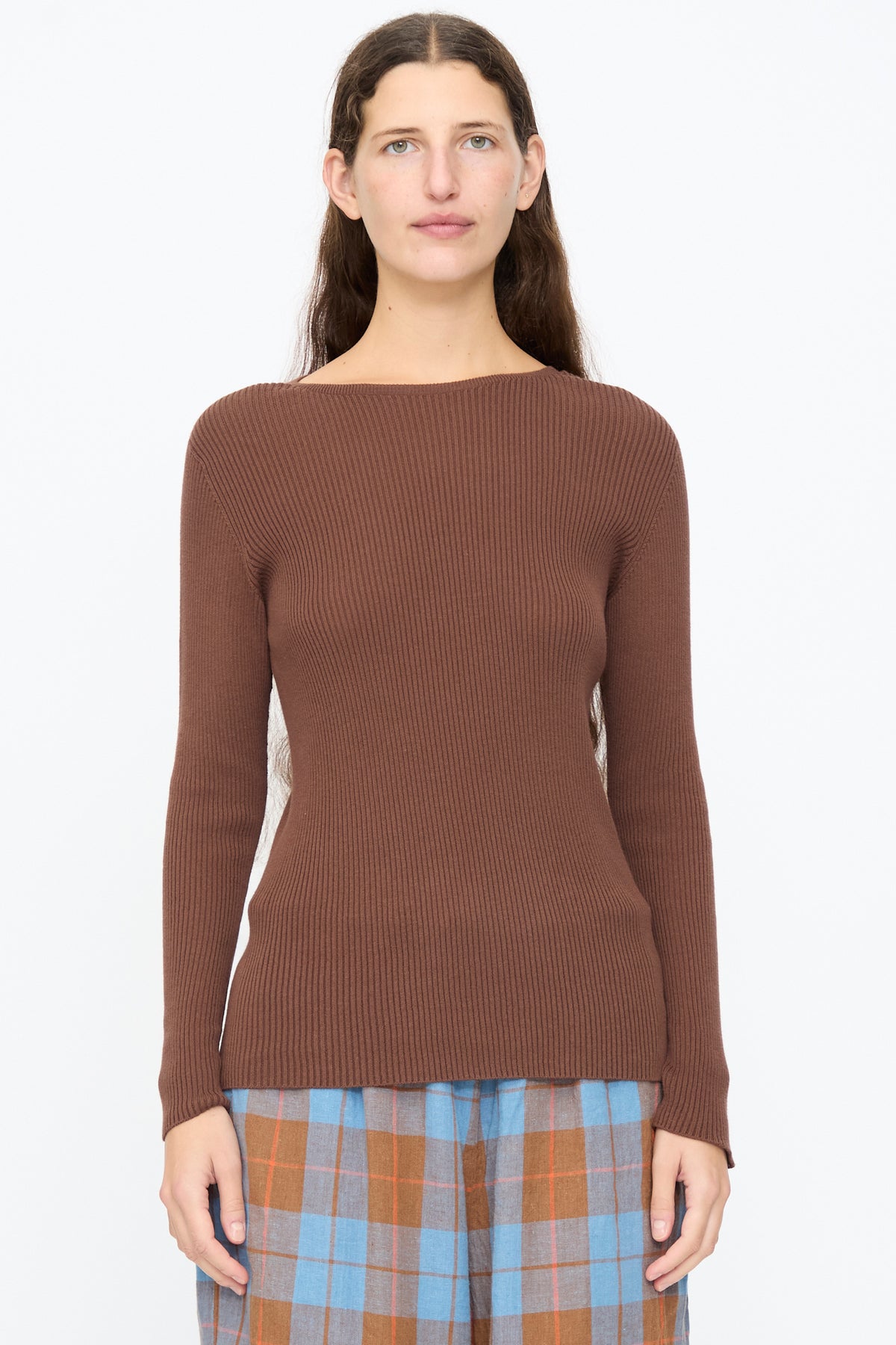 A person wearing an Ichi Antiquités Cotton Rib Knit Pullover in brown, featuring a slim fit, long sleeves, and a boat neckline.