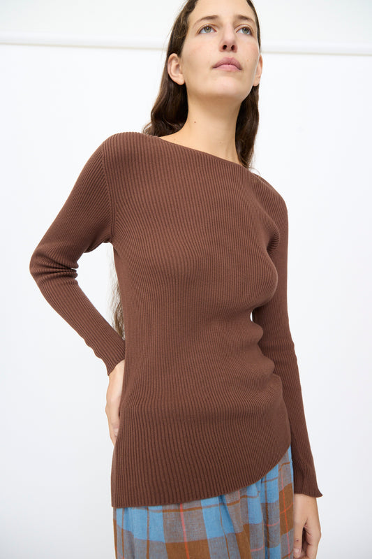 A person wearing a slim-fit, brown, long-sleeved, rib knit Ichi Antiquités Cotton Rib Knit Pullover with a wide neckline.