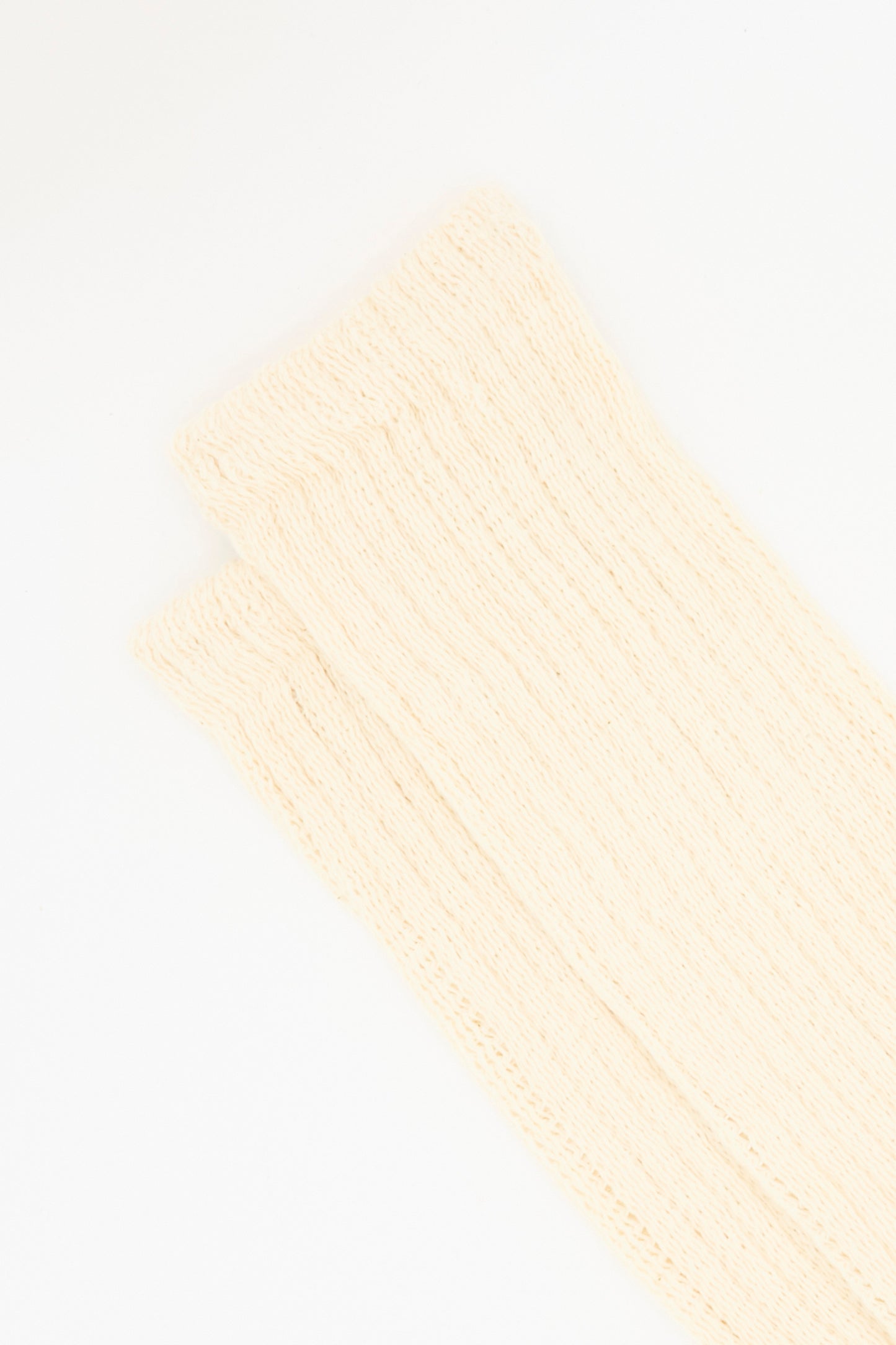 A close-up of two Rib Sock in Natural by Ichi Antiquités, cream-colored with a ribbed cotton design, made in Japan and displayed on a white background.