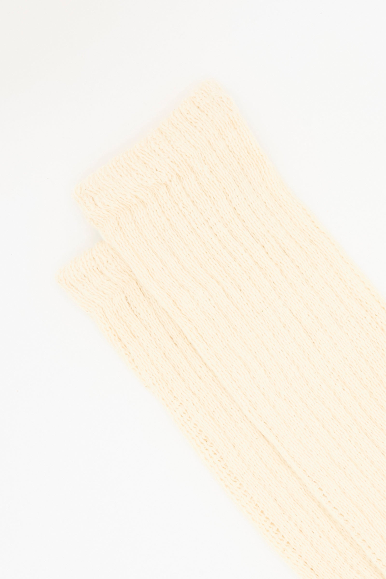 A close-up of two Rib Sock in Natural by Ichi Antiquités, cream-colored with a ribbed cotton design, made in Japan and displayed on a white background.