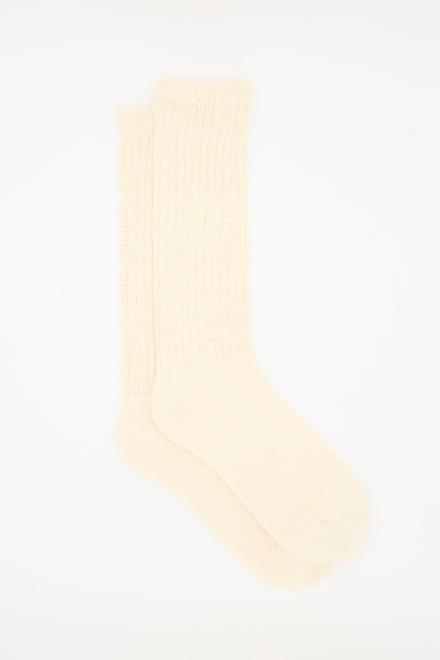 The Ichi Antiquités Rib Sock in Natural is a pair of cream-colored, ribbed cotton socks made in Japan, designed to reach over the ankle.