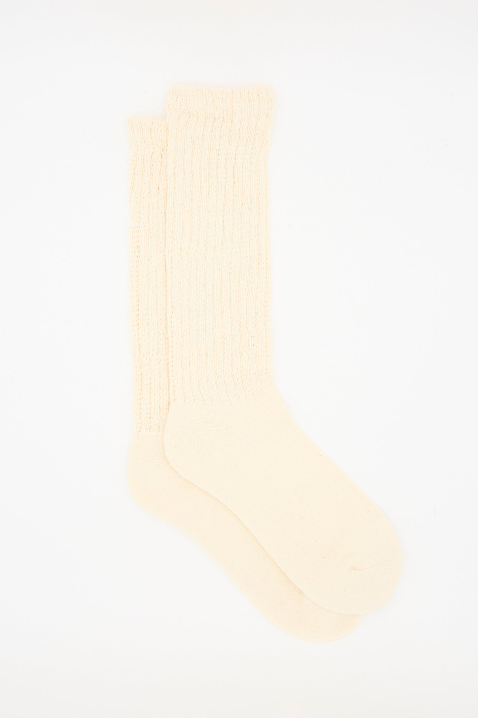 The Ichi Antiquités Rib Sock in Natural is a pair of cream-colored, ribbed cotton socks made in Japan, designed to reach over the ankle.
