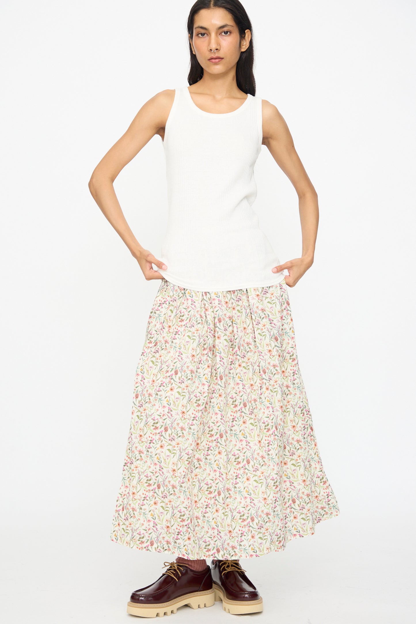 Someone wearing the Ichi Antiquités Cotton Rib Tank Top in White, a long floral skirt, and brown lace-up shoes stands against a plain white background.