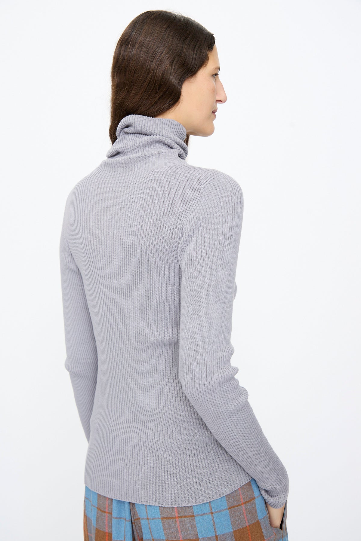A person wearing an Ichi Antiquités Cotton Rib Turtleneck in Light Gray, a slim-fit, long-sleeved ribbed turtleneck.