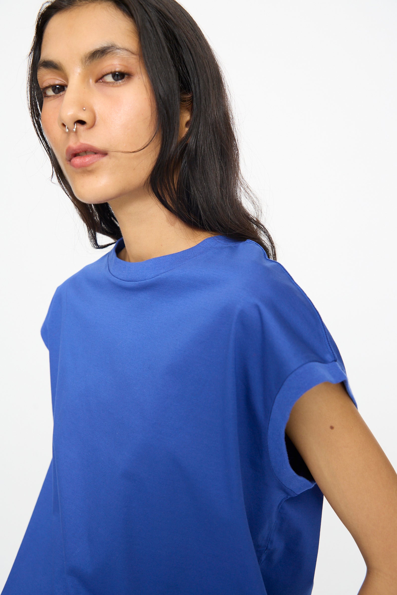 A person with long dark hair and a nose ring models the Ichi Antiquités Cotton Sleeveless Pullover in Blue, standing against a plain white background.