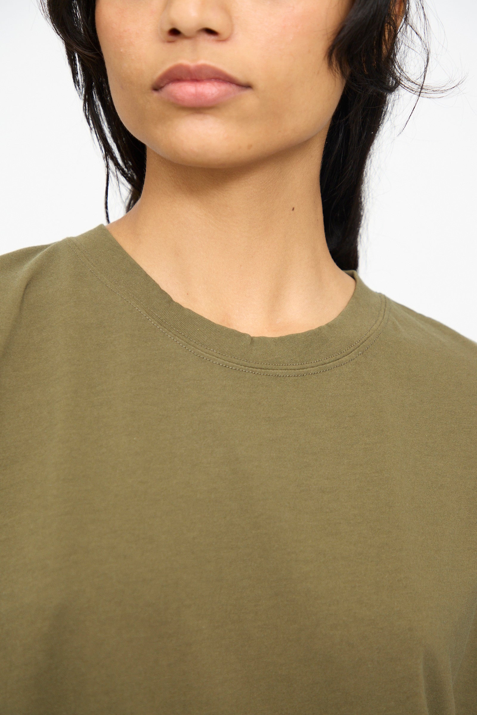 A person with long dark hair, shown from the shoulders up and facing forward, wears the Ichi Antiquités Cotton Sleeveless Tee in Khaki.