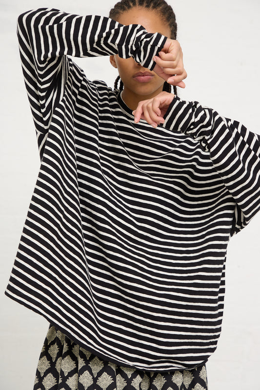 Woman posing with an Ichi Antiquités Cotton Stripe Loose Pullover in Black and Natural, covering one eye with her hand.