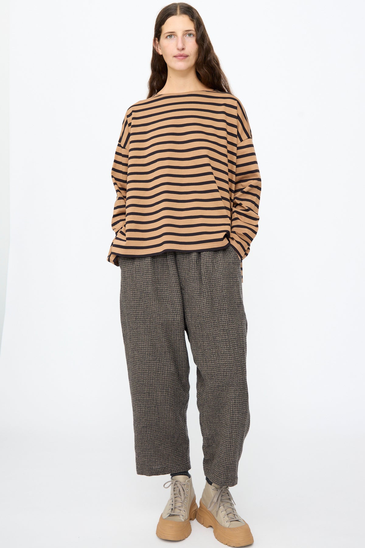A person wearing an Ichi Antiquités Cotton Stripe Pullover in Mocha and Navy with textured grey trousers and beige platform sneakers, hands in their pockets.