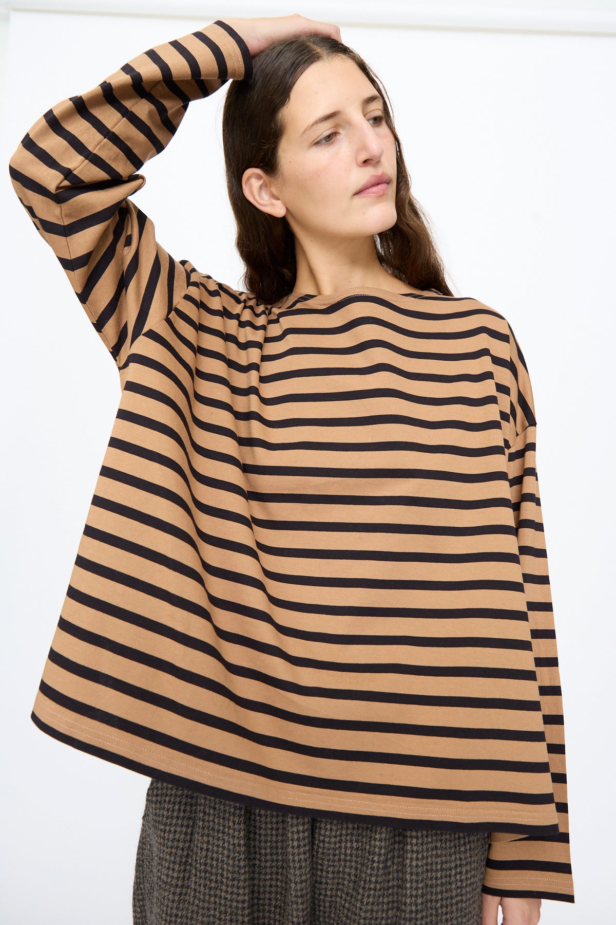 A person wearing a relaxed, long-sleeve Ichi Antiquités Cotton Stripe Pullover in Mocha and Navy with brown and black horizontal stripes.