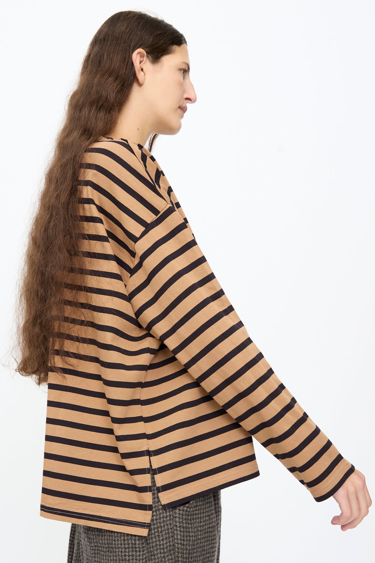 A side view of a person wearing an Ichi Antiquités Cotton Stripe Pullover in Mocha and Navy, featuring a relaxed fit with long sleeves and side hem slits.