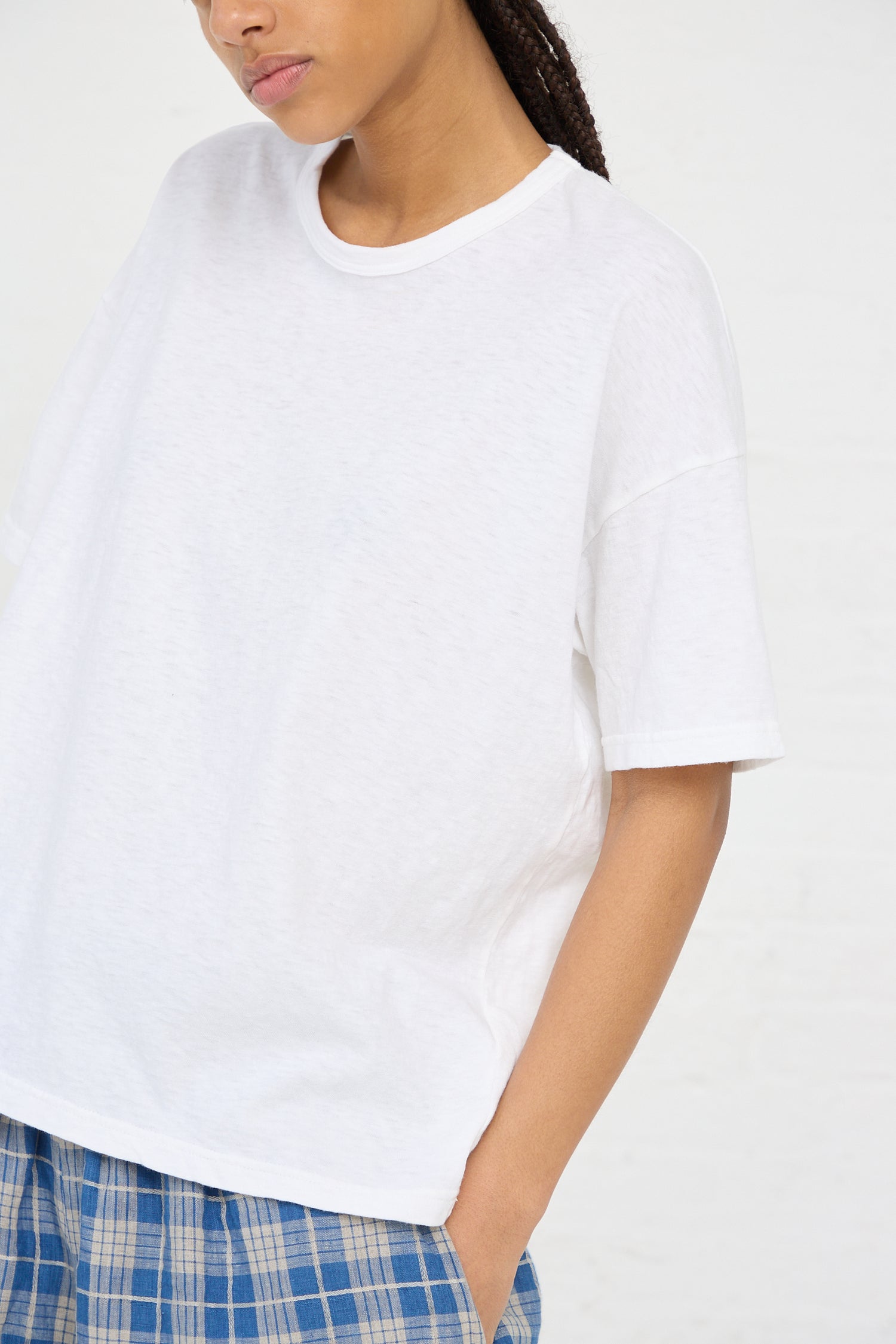 A person wearing an oversized Ichi Antiquités Cotton T-Shirt in White and plaid pants.