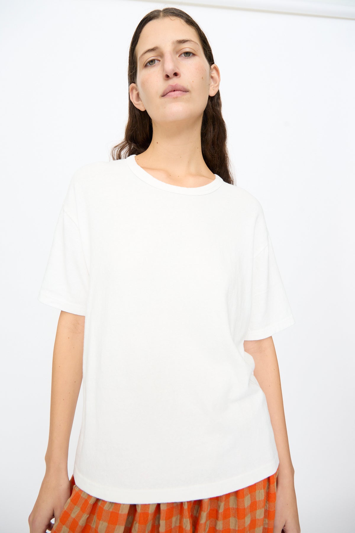 A person wears an oversized, short-sleeved white Cotton T-Shirt in White by Ichi Antiquités with a crew neck.
