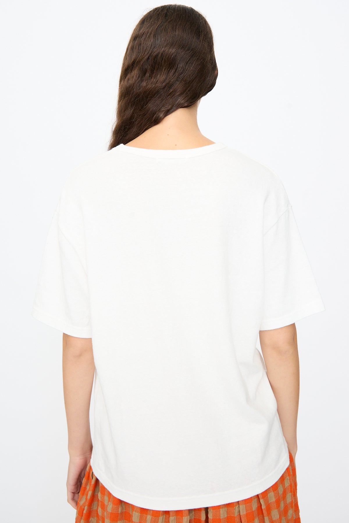 Back view of a person wearing an oversized Ichi Antiquités Cotton T-Shirt in White and an orange and brown plaid skirt.