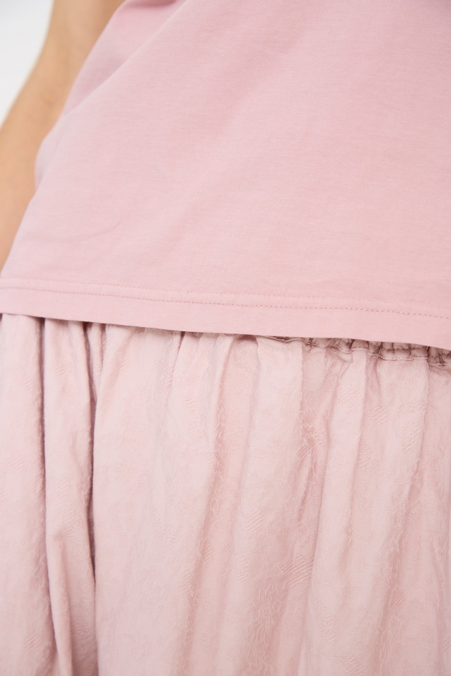 Close-up of a person wearing an Ichi Antiquités Cotton Tank in Pink and a textured, dusty-rose skirt. The lightweight cotton fabric of the skirt appears to be gathered and slightly wrinkled.