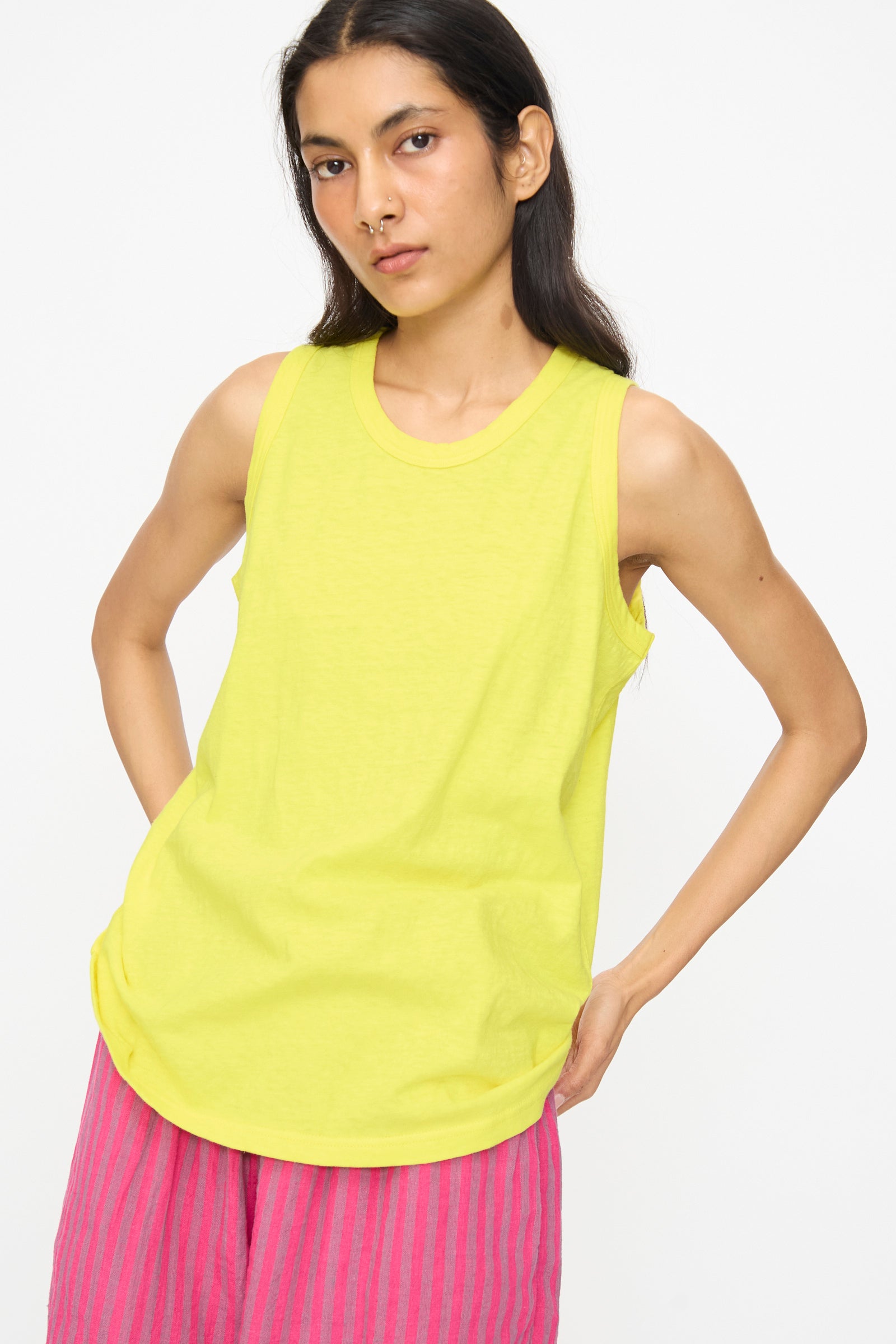 Model wears the Ichi Antiquités Cotton Tank Top in Yellow with pink striped pants, standing against a plain white background.