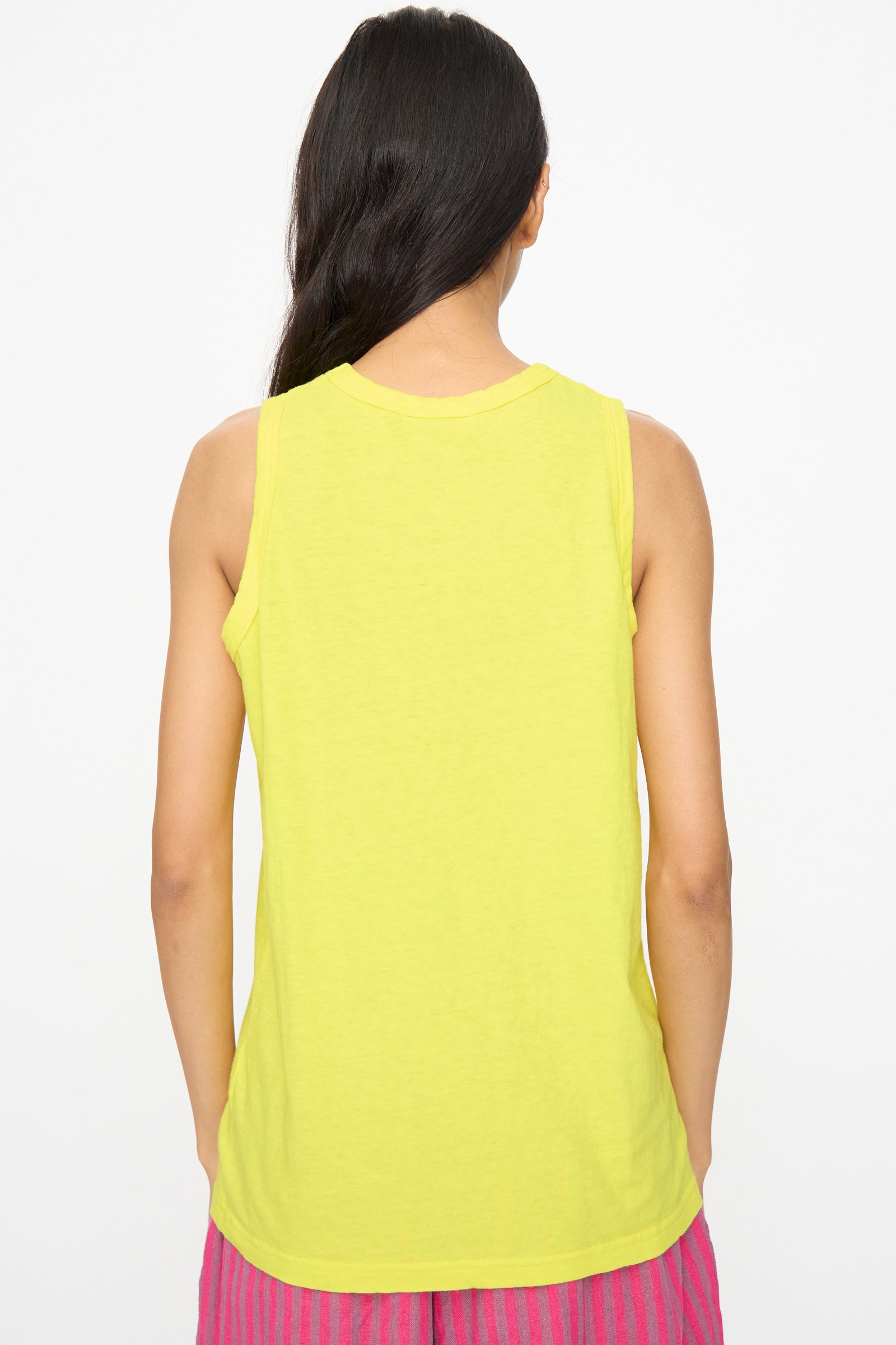 A person with long dark hair, seen from behind, wears the Ichi Antiquités Cotton Tank Top in Yellow and pink striped bottoms, made in Japan, against a white background.
