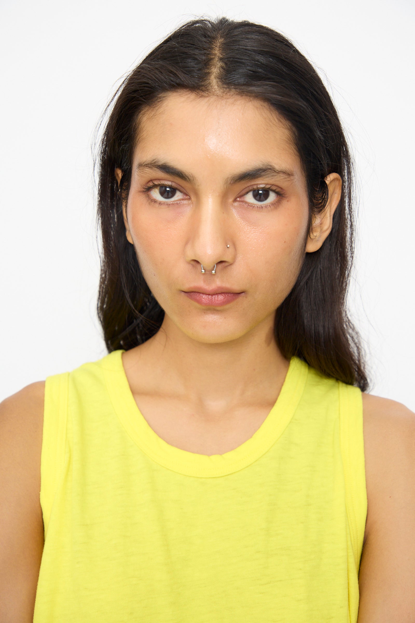 A person with long dark hair and a septum piercing wears the Ichi Antiquités Cotton Tank Top in Yellow, made in Japan, looking directly at the camera with a neutral expression.
