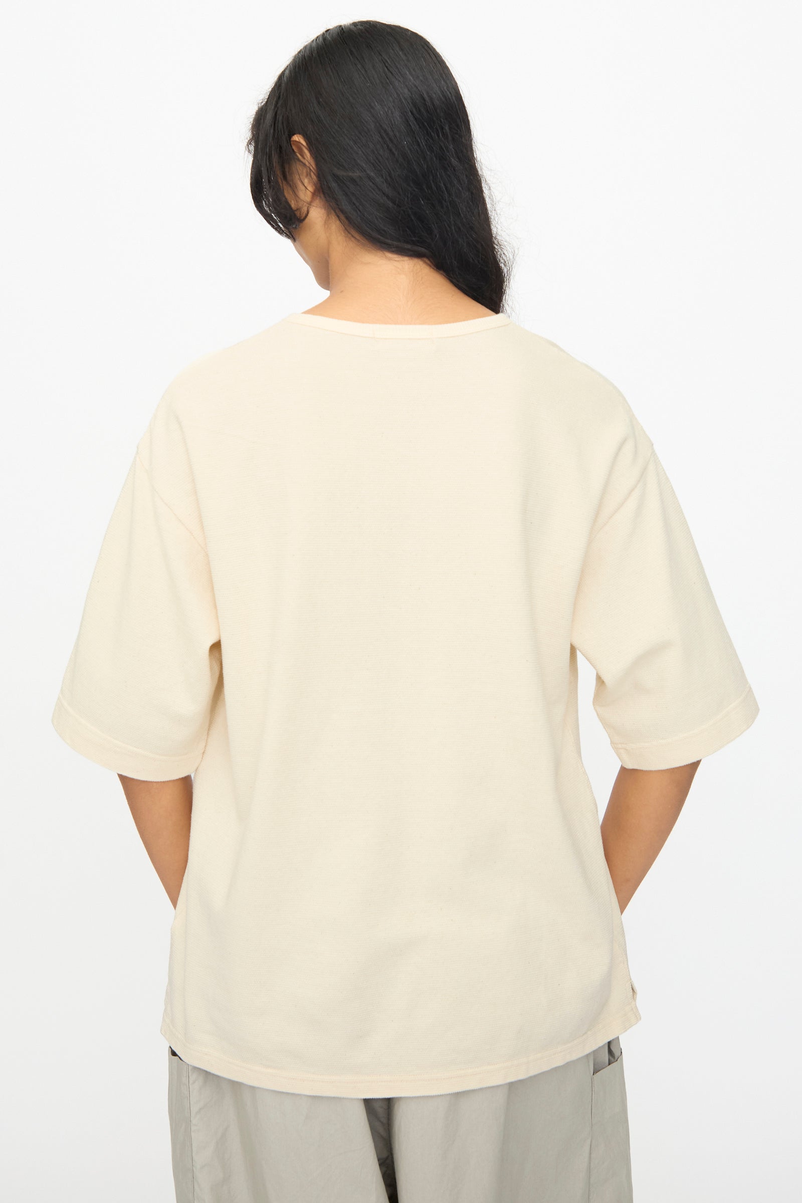 A person with long dark hair wears the Ichi Antiquités Cotton Thermal Henley Neck Pullover in Ivory, shown from the back against a plain white background.