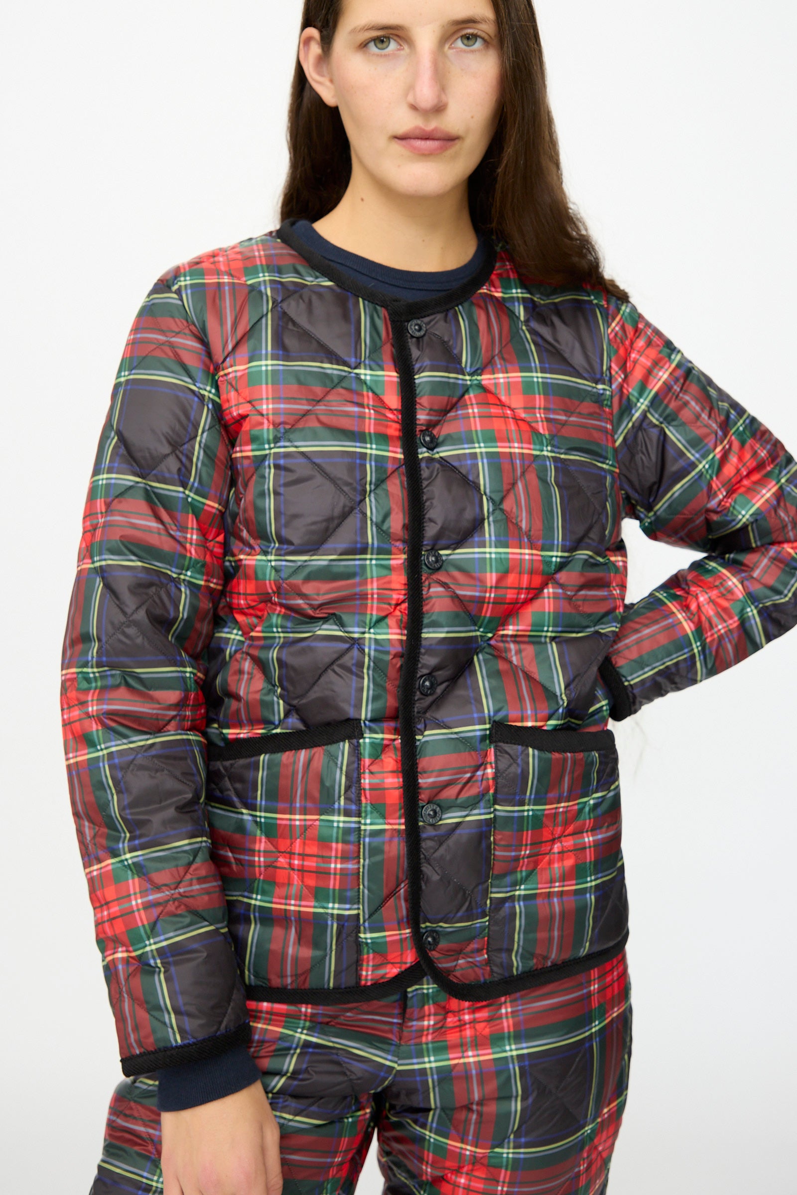 A person wearing the Ichi Antiquités Down Jacket in Black Tartan with black corduroy trim and matching pants, standing against a plain white background.