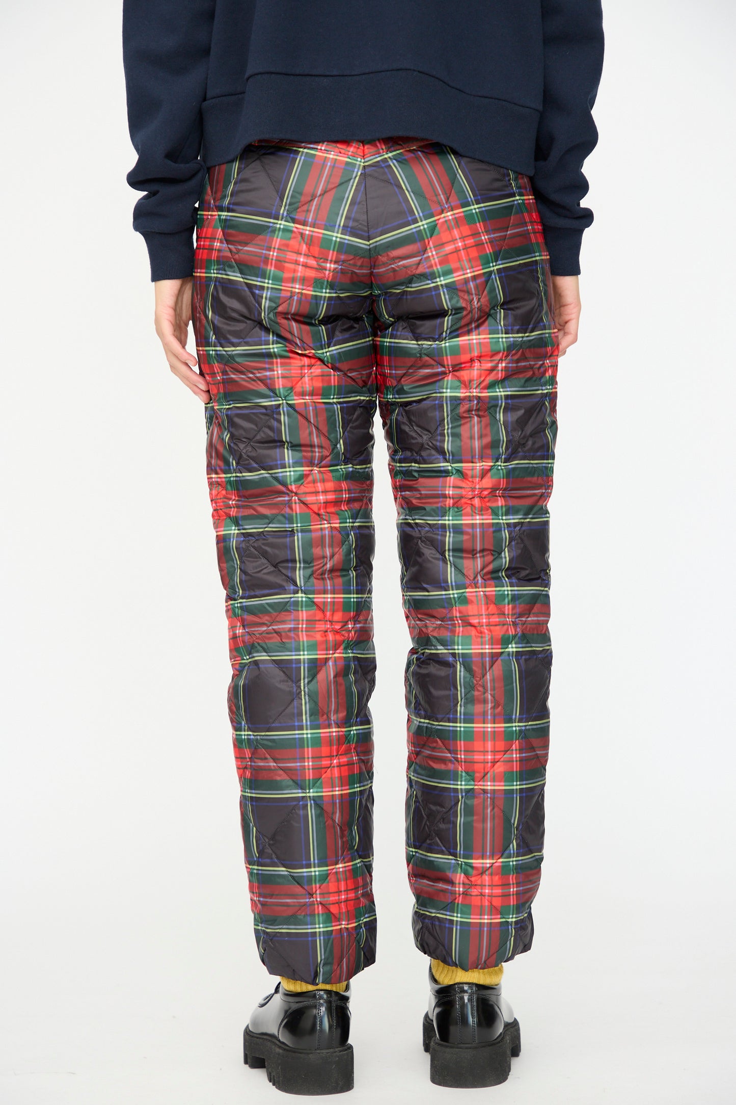 Person wears Ichi Antiquités Down Pants in Black Tartan with a relaxed fit, paired with black shoes and a navy sweatshirt, shown from the back against a plain background.