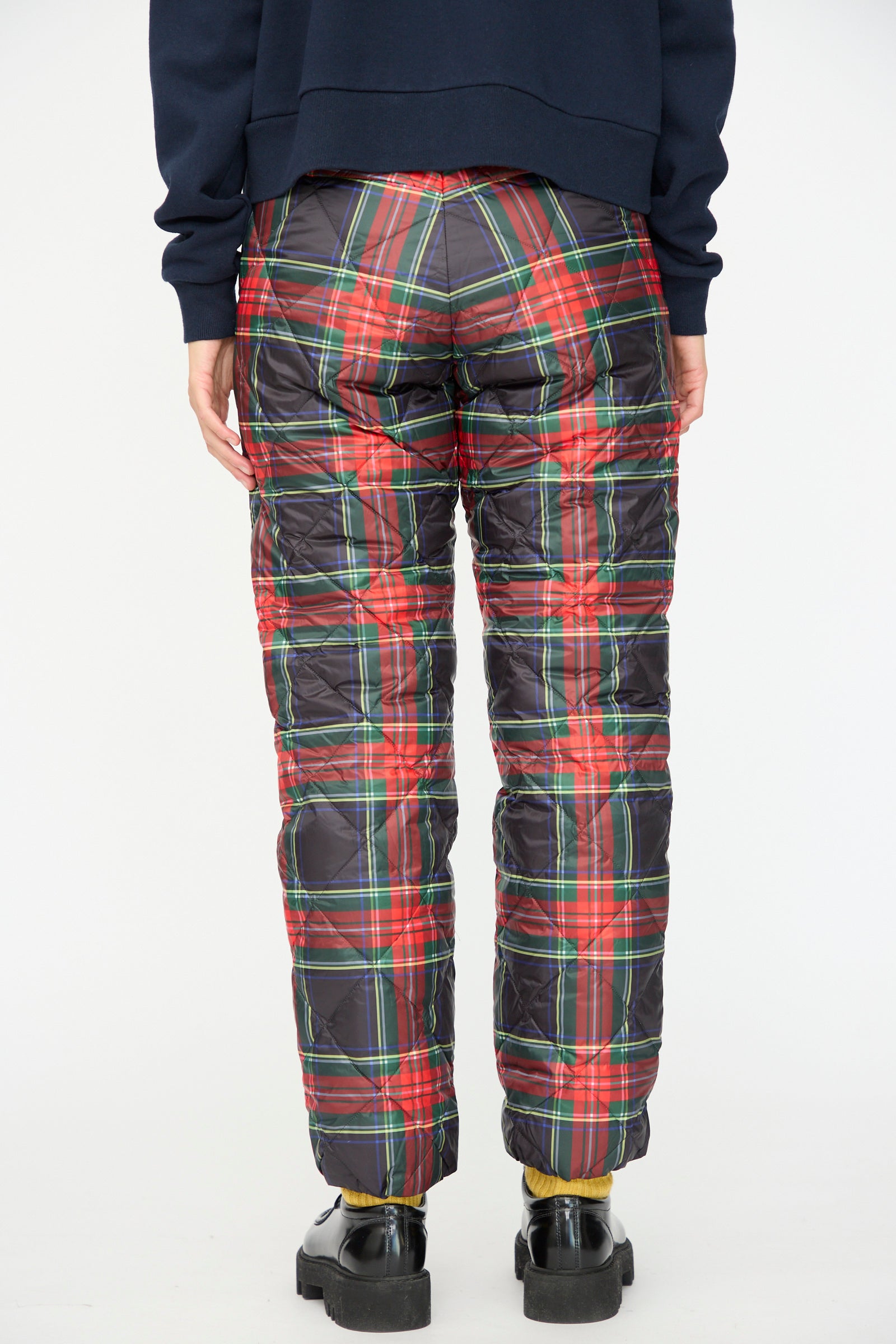 Person wears Ichi Antiquités Down Pants in Black Tartan with a relaxed fit, paired with black shoes and a navy sweatshirt, shown from the back against a plain background.