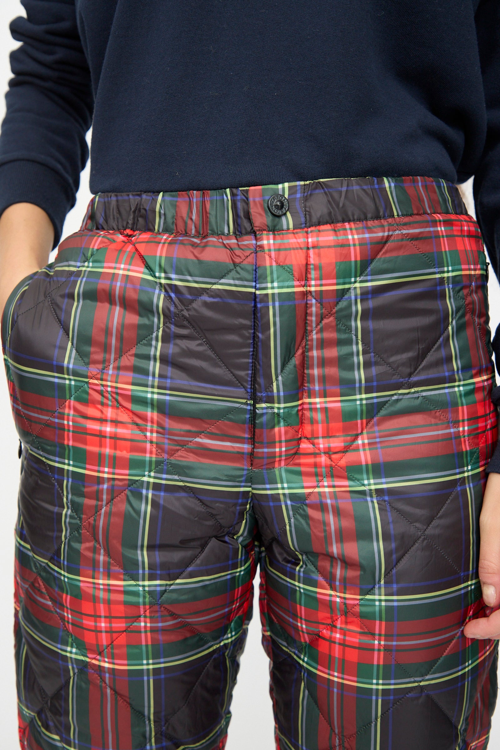 A person wearing Ichi Antiquités Down Pants in Black Tartan paired with a navy long-sleeve top.