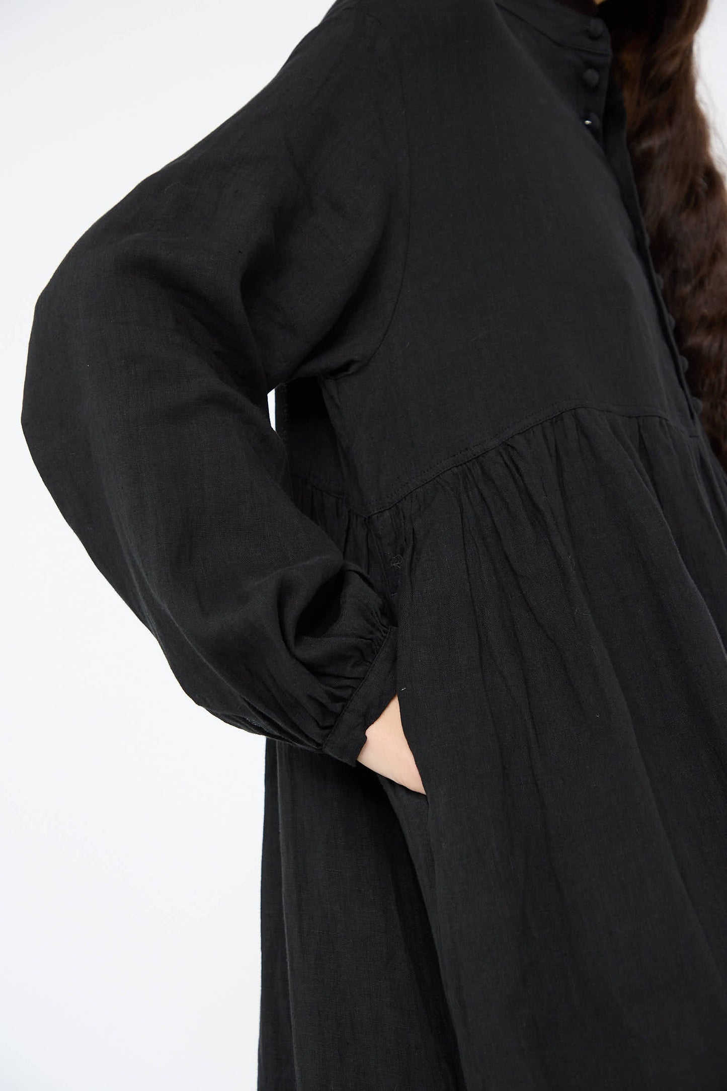 A person wearing the French Linen Dress in Black by Ichi Antiquités with their hand in the pocket.