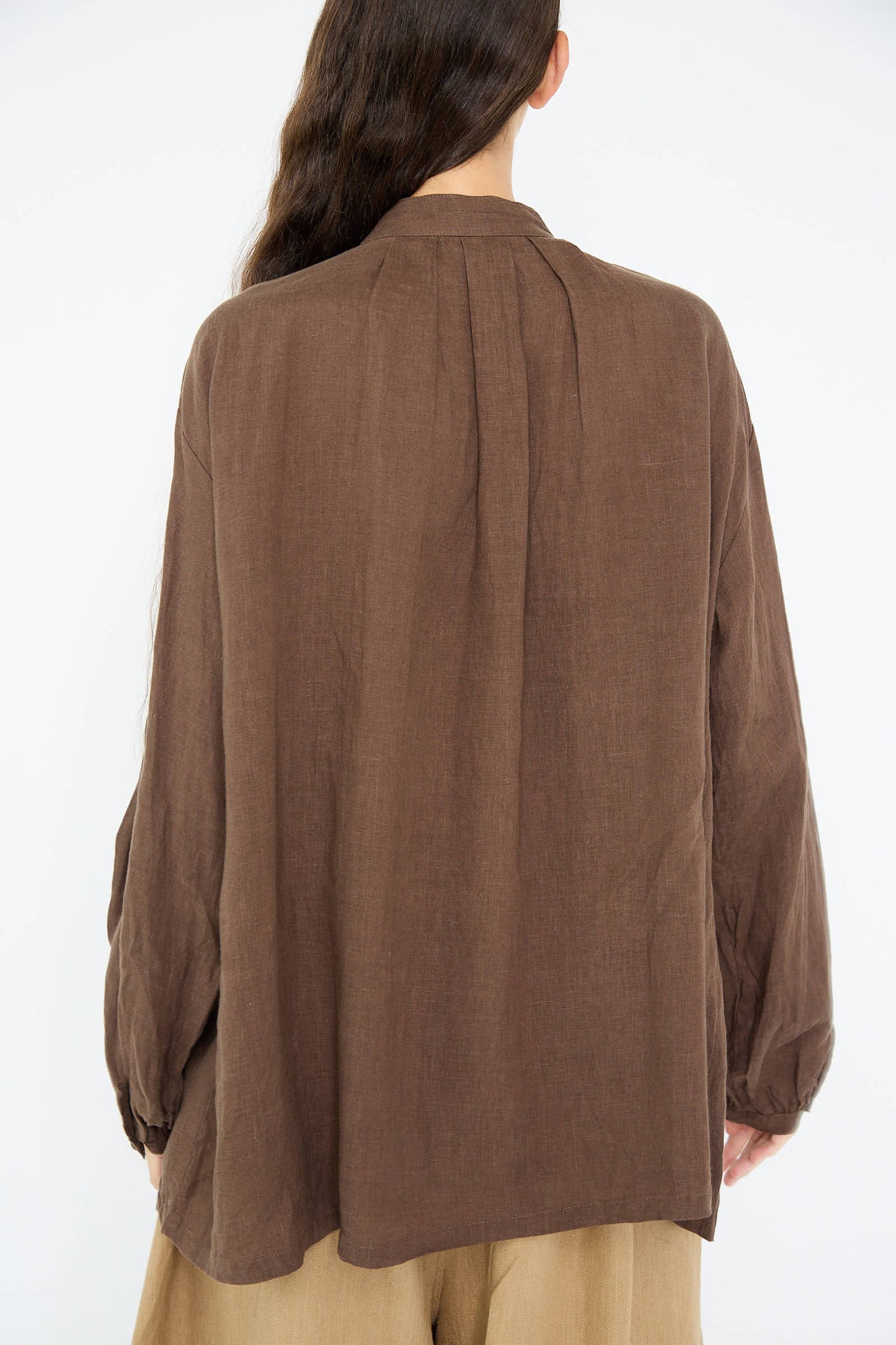 A person with long hair is wearing a loose Ichi Antiquités French Linen Shirt in Brown. The photo is taken from the back.