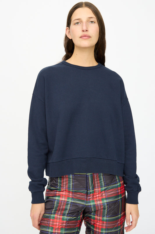A person wears the Ichi Antiquités French Terry Cotton Pullover in Navy with red-green plaid pants, standing against a plain white background.