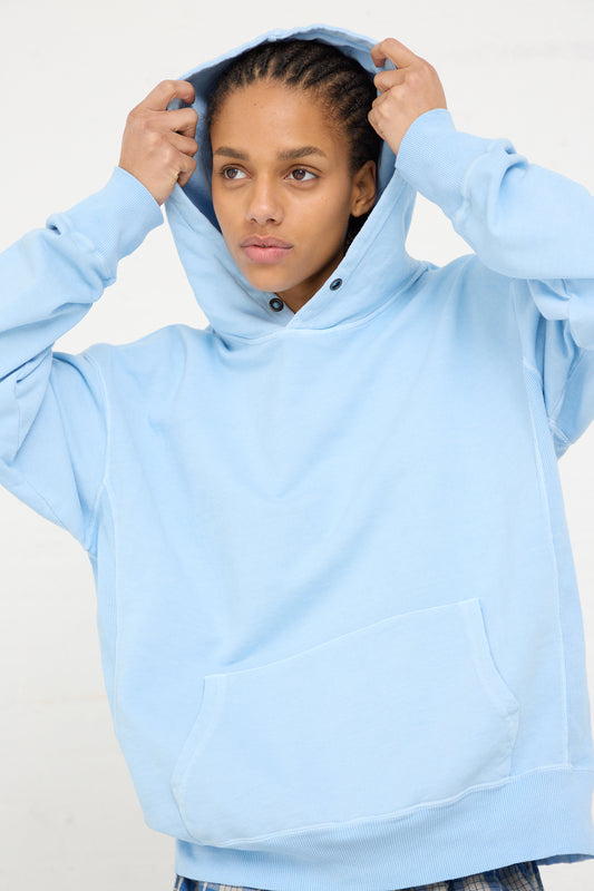 Woman adjusting the oversized hood of her blue Ichi Antiquités French Terry Hoodie.
