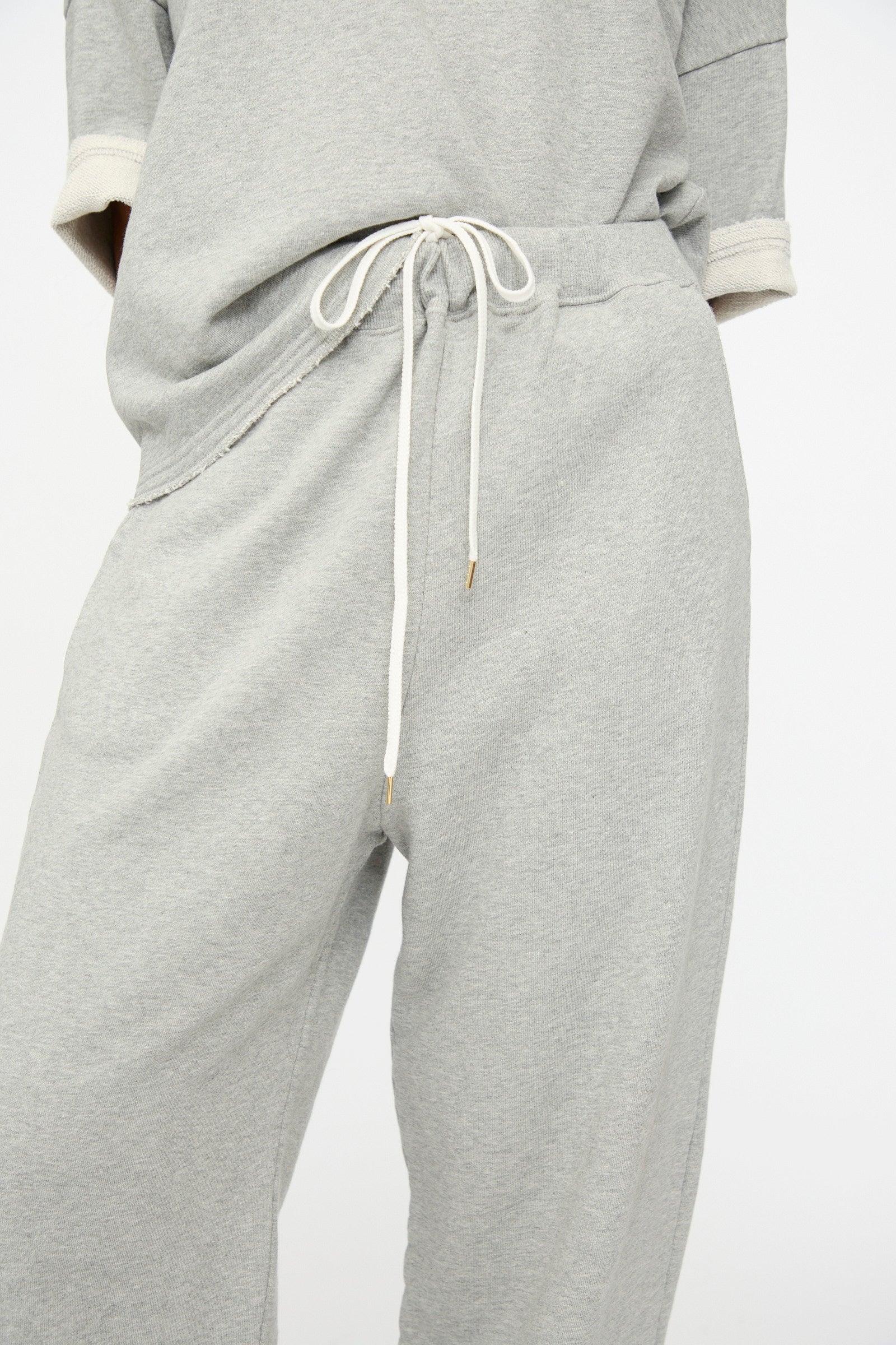 Someone is shown from shoulders to thighs wearing Ichi Antiquités French Terry Pants in Gray, featuring an elastic waistband and drawstring, paired with a matching top.