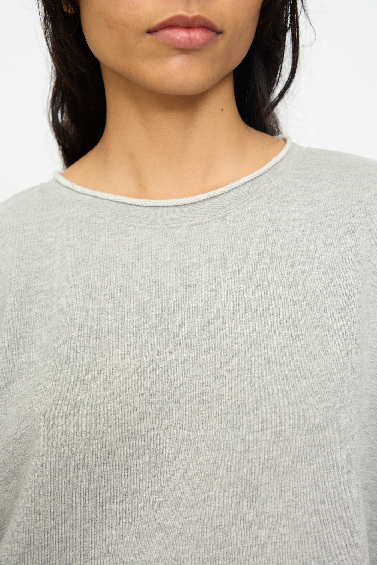 A close-up shows a person wearing the Ichi Antiquités French Terry Pullover in Gray, with the lower half of their face and upper torso visible against a plain background.