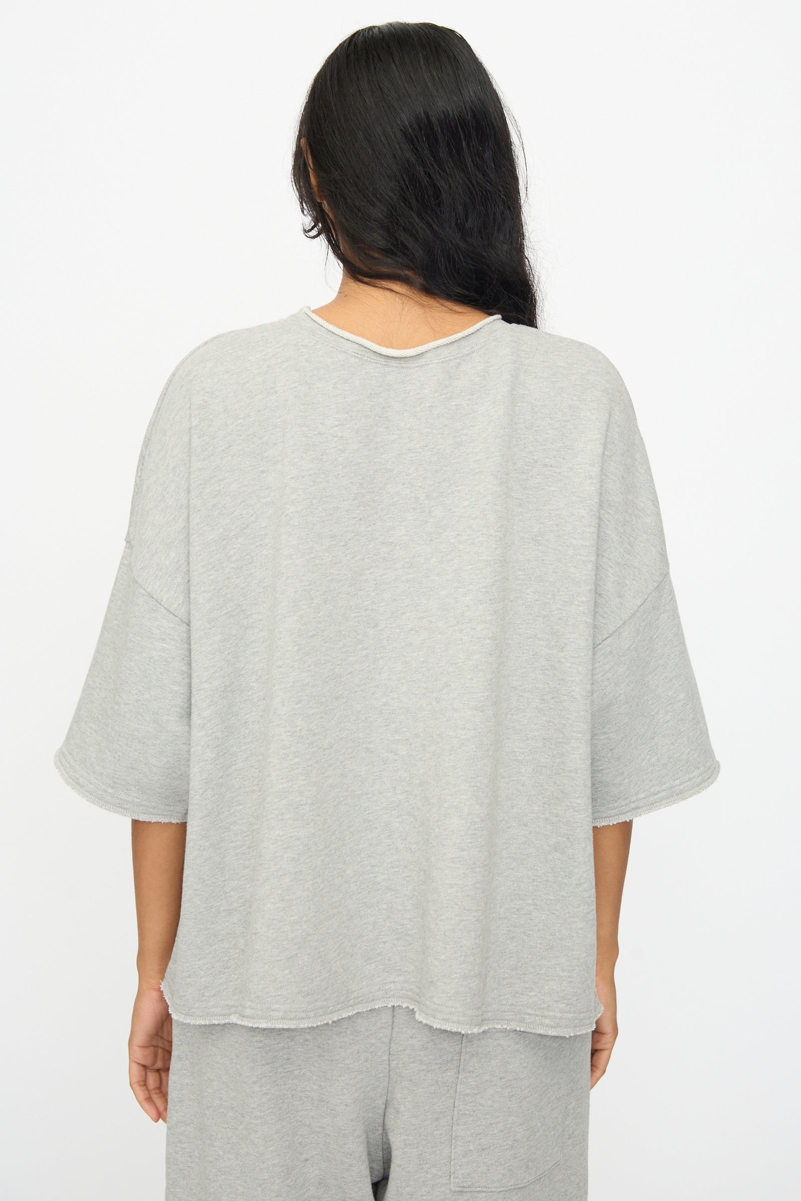 Person with long dark hair wears the Ichi Antiquités French Terry Pullover in Gray with matching pants, shown from the back against a plain white background. This loose-fitting cotton set is made in Japan.