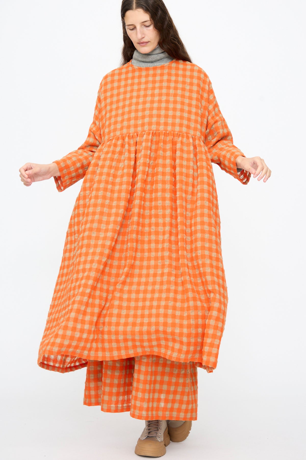Person wearing an Ichi Antiquités Gingham Check Dress in Beige and Orange over matching wide-leg trousers and a grey turtleneck.