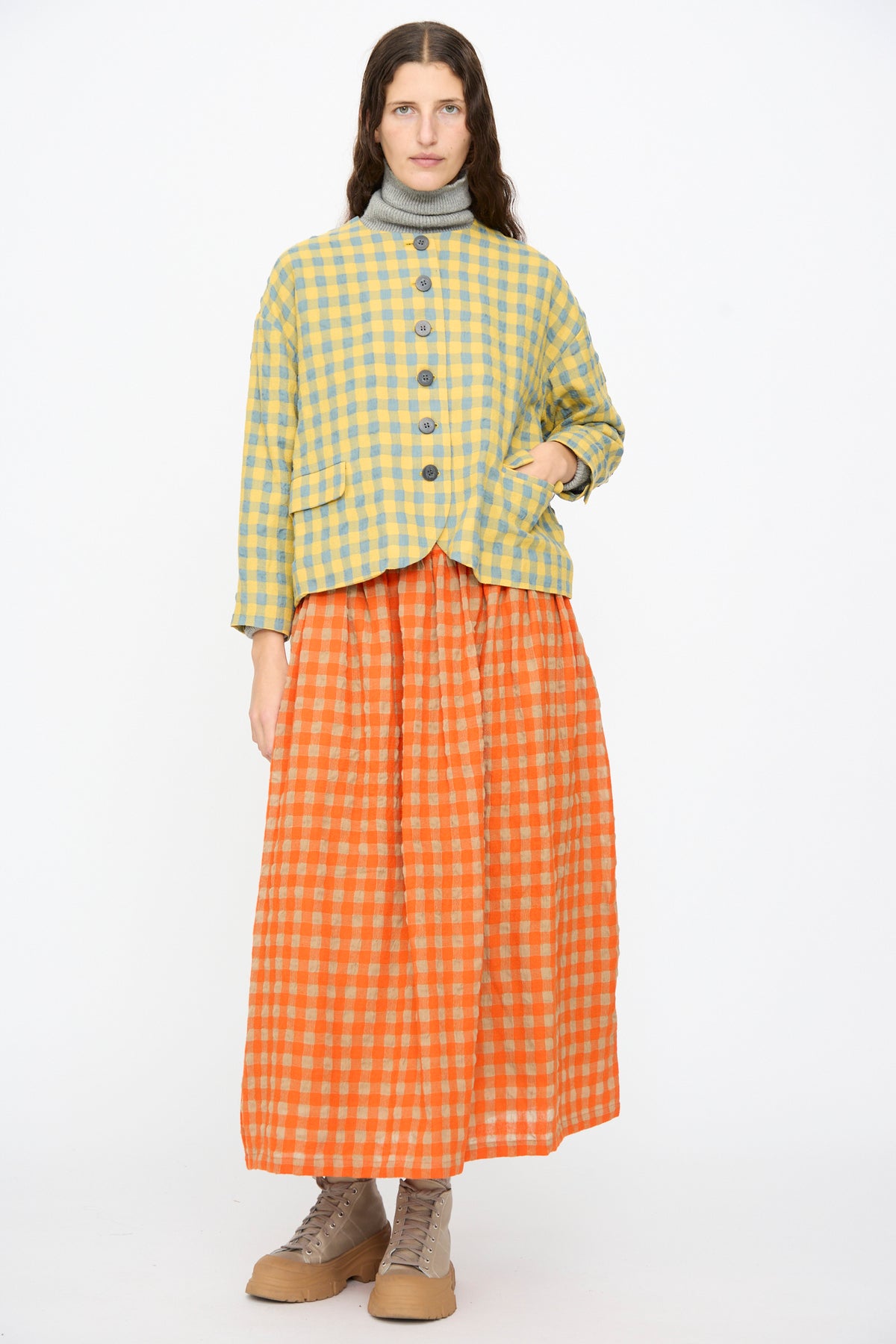 A person wearing an Ichi Antiquités Gingham Check Jacket in Blue and Yellow over an orange gingham maxi skirt and beige lace-up boots.