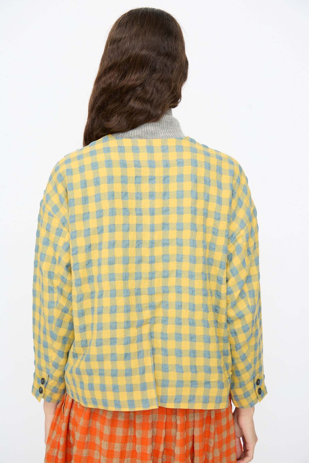 Back view of a person wearing an Ichi Antiquités Gingham Check Jacket in Blue and Yellow over a red and orange checkered skirt.