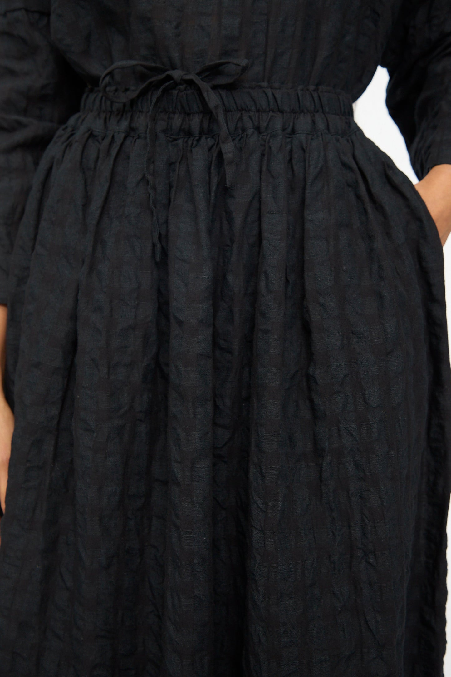 Close-up of a person wearing the Ichi Antiquités Gingham Check Skirt in Black, featuring a textured fabric, elastic waistband, drawstring, side pocket, and an A-line silhouette for comfort and style.
