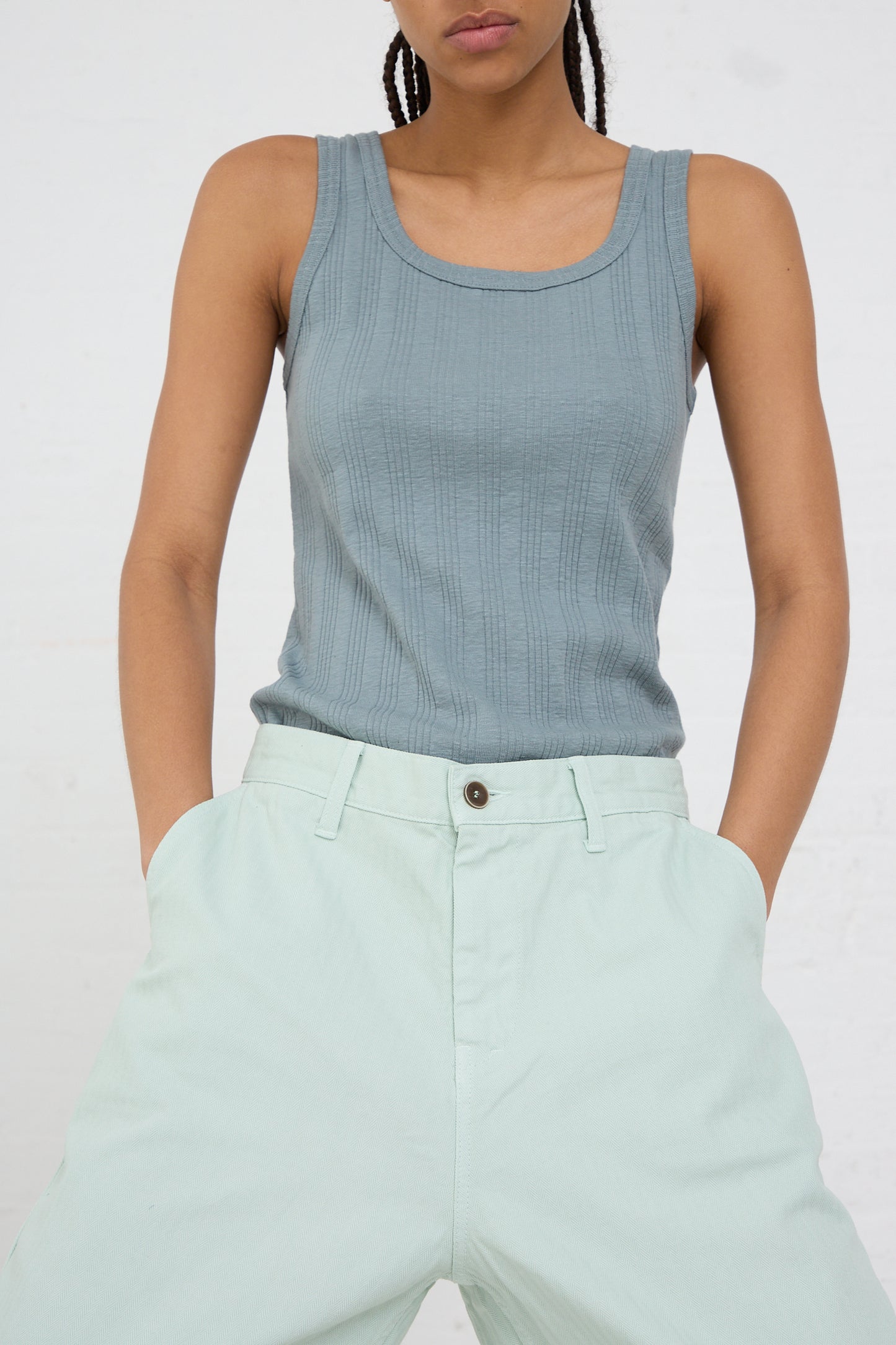 Woman wearing a grey tank top and Ichi Antiquités Herringbone Garment Dye Pant in Ice Green against a white background.