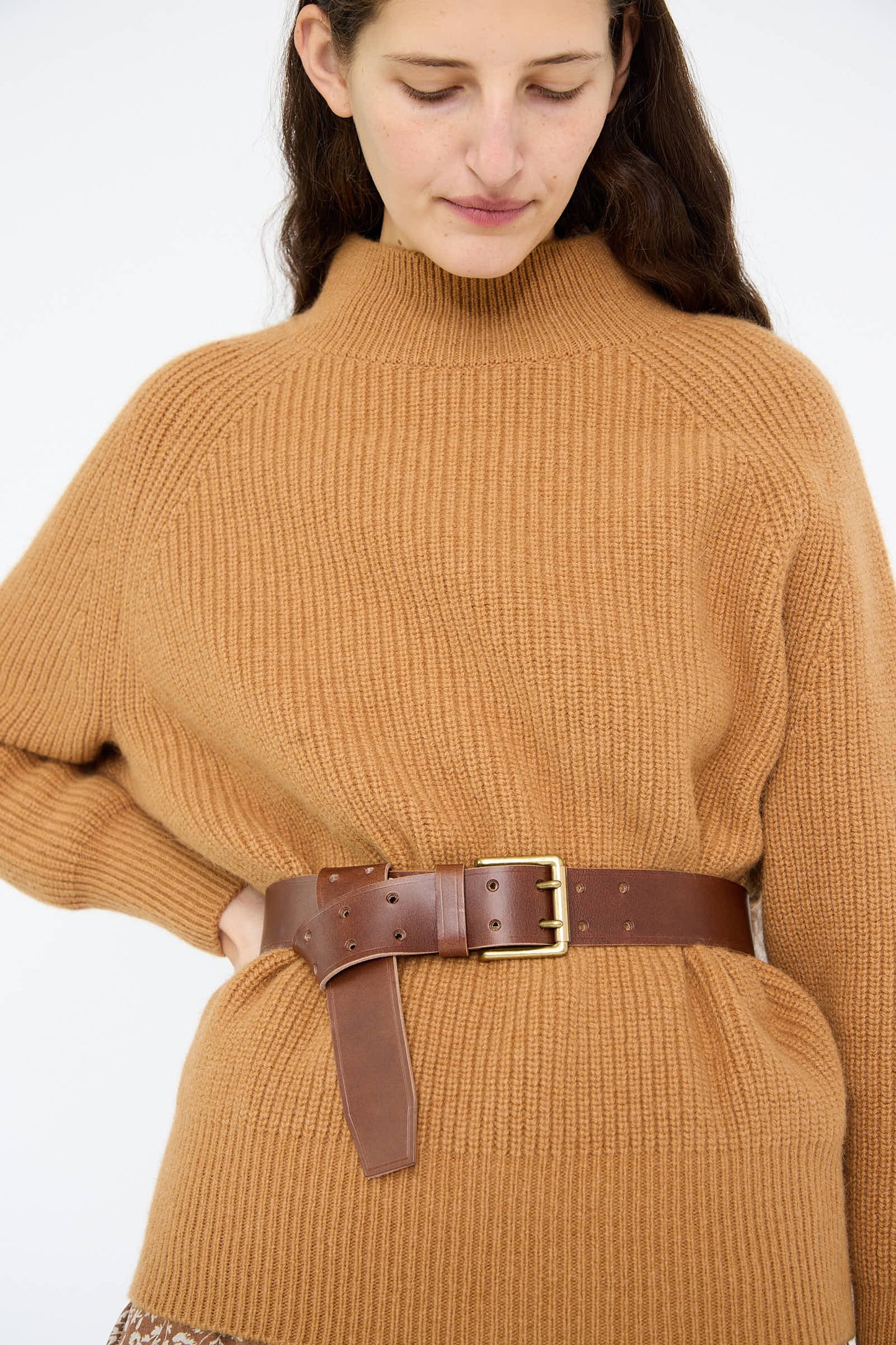 A person wearing a brown oversized sweater cinched with Ichi Antiquités' Leather Belt in Dark Brown featuring a brass buckle.