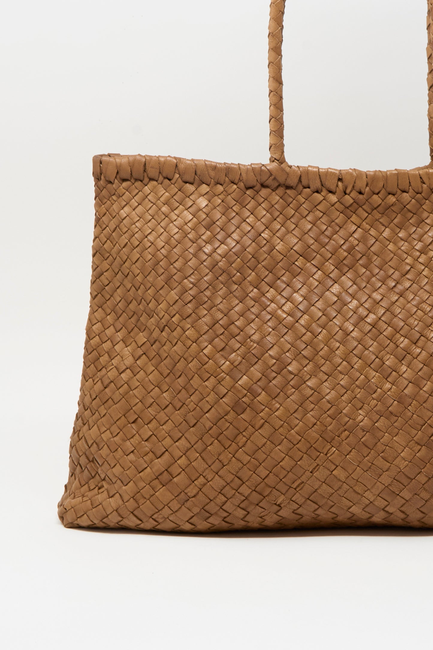 A close-up of the Ichi Antiquités Leather Tote Bag in Brown highlights its woven design and two sturdy handles, set against a plain white background.