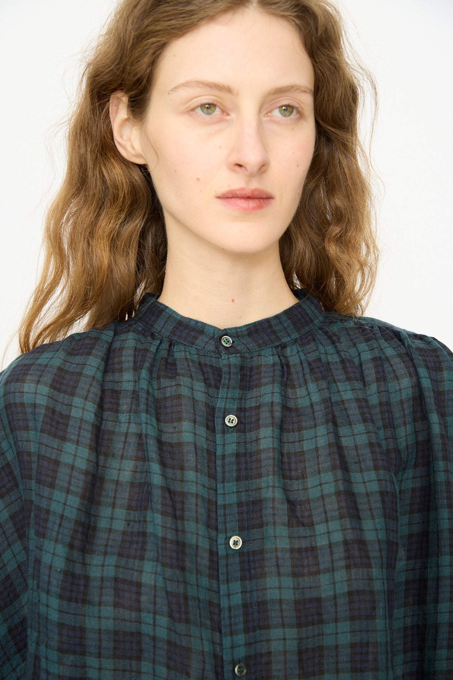 A person with wavy light brown hair wears the Ichi Antiquités Linen Canvas Shirt in Black Watch, facing slightly left against a plain light background.