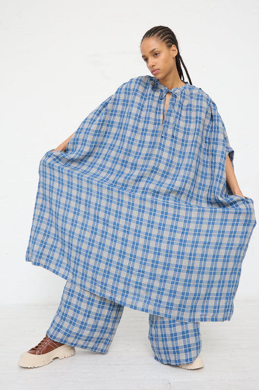 A person wearing an oversized Ichi Antiquités Linen Check Dress in Dark Indigo and Natural Linen stands against a white background.