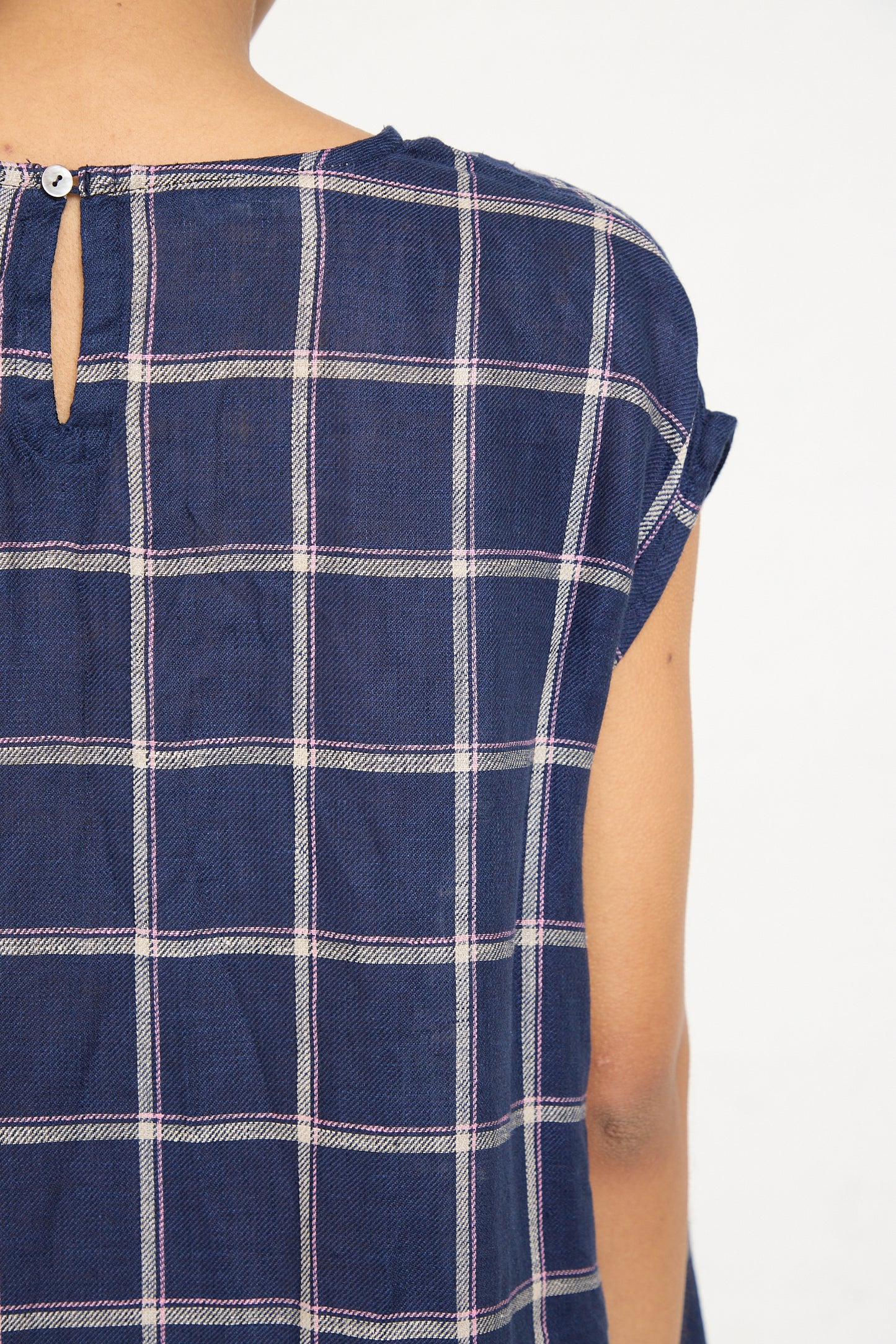 Close-up of a person wearing an Ichi Antiquités Linen Check Dress in Navy with a button and loop closure at the back.